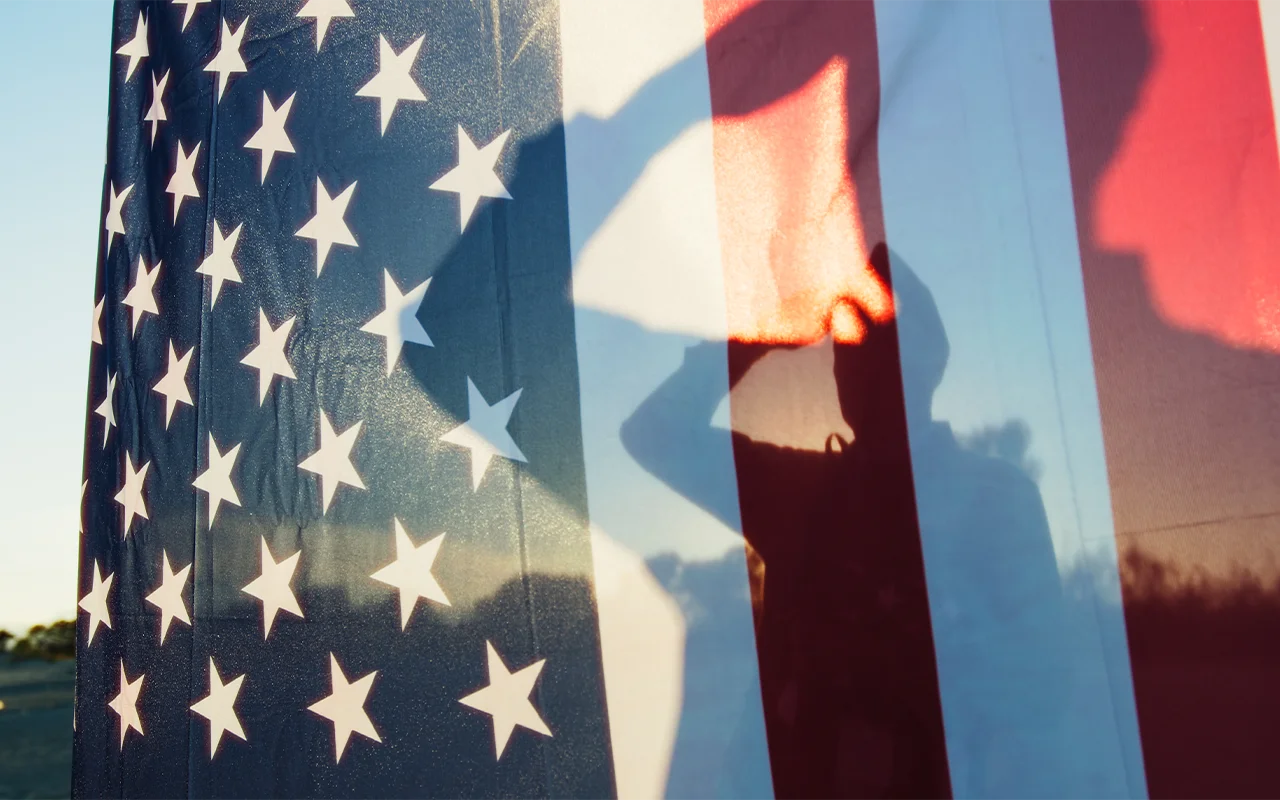 shadow of soldier saluting flag